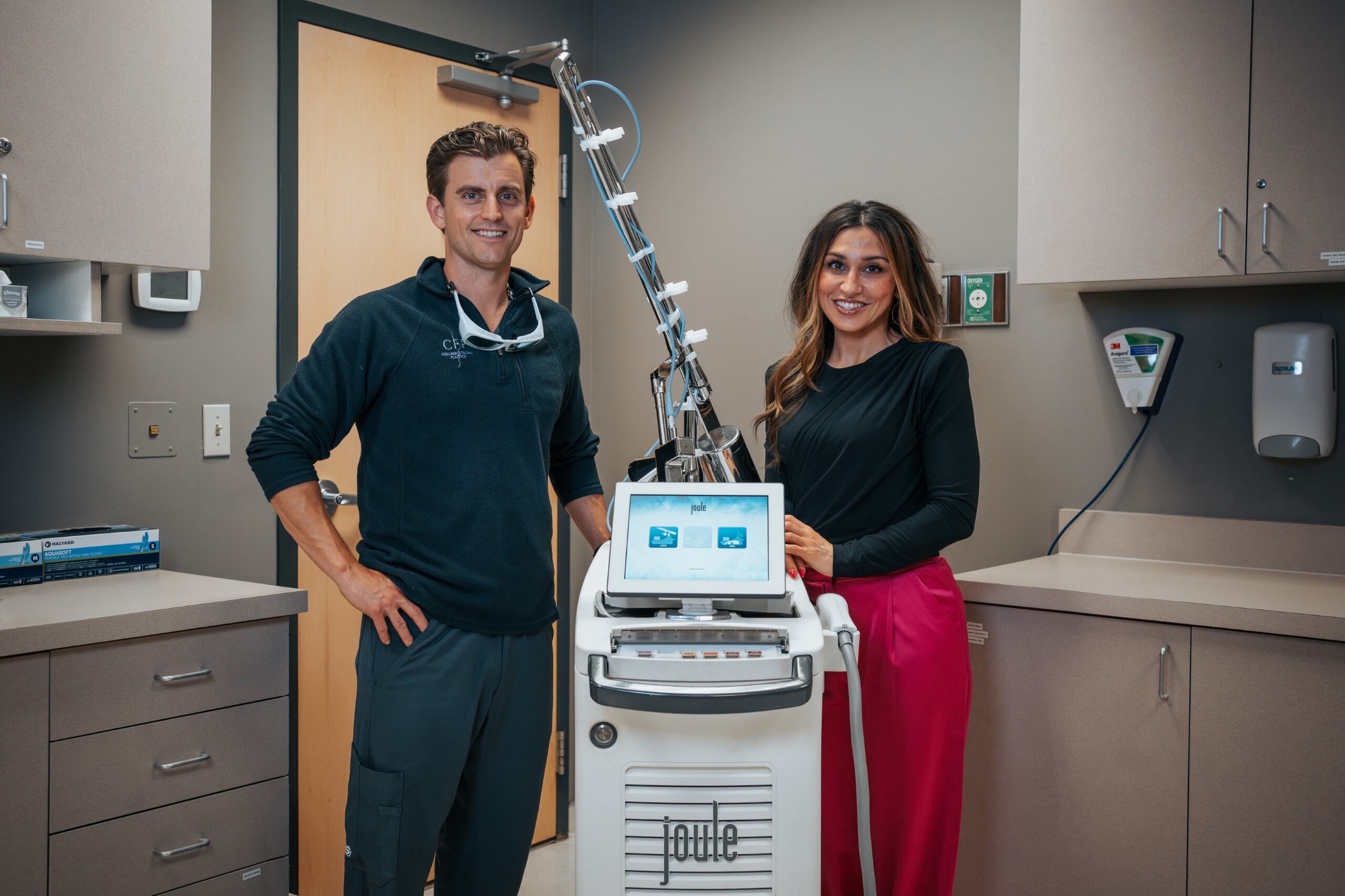 A man and a woman stand next to a medical device