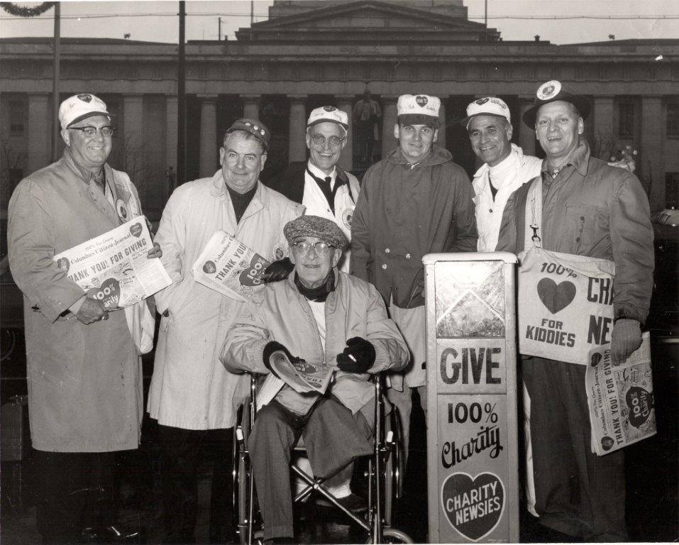 A black and white photo of several men wearing food caps