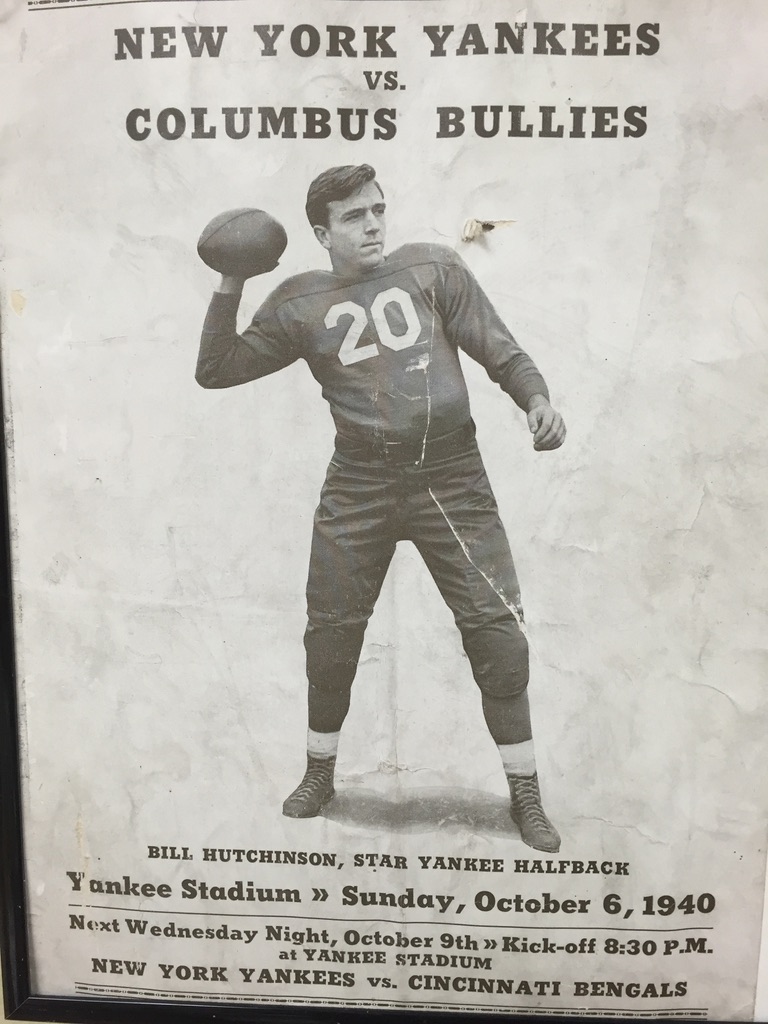 A black and white photo of a man holding a football