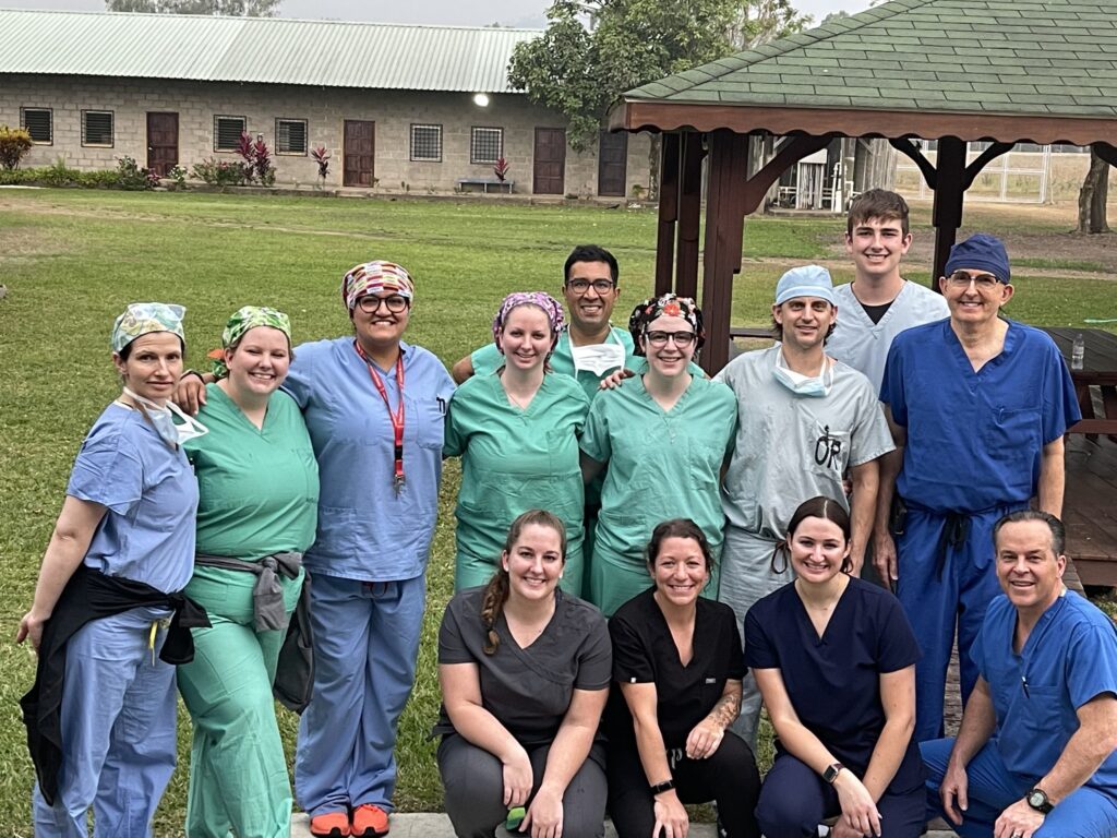 A group of people stand outside in scrubs
